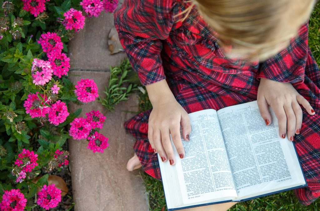 A young girl sits in a garden and reads the Book of Mormon. via lds.org © intellectual reserve